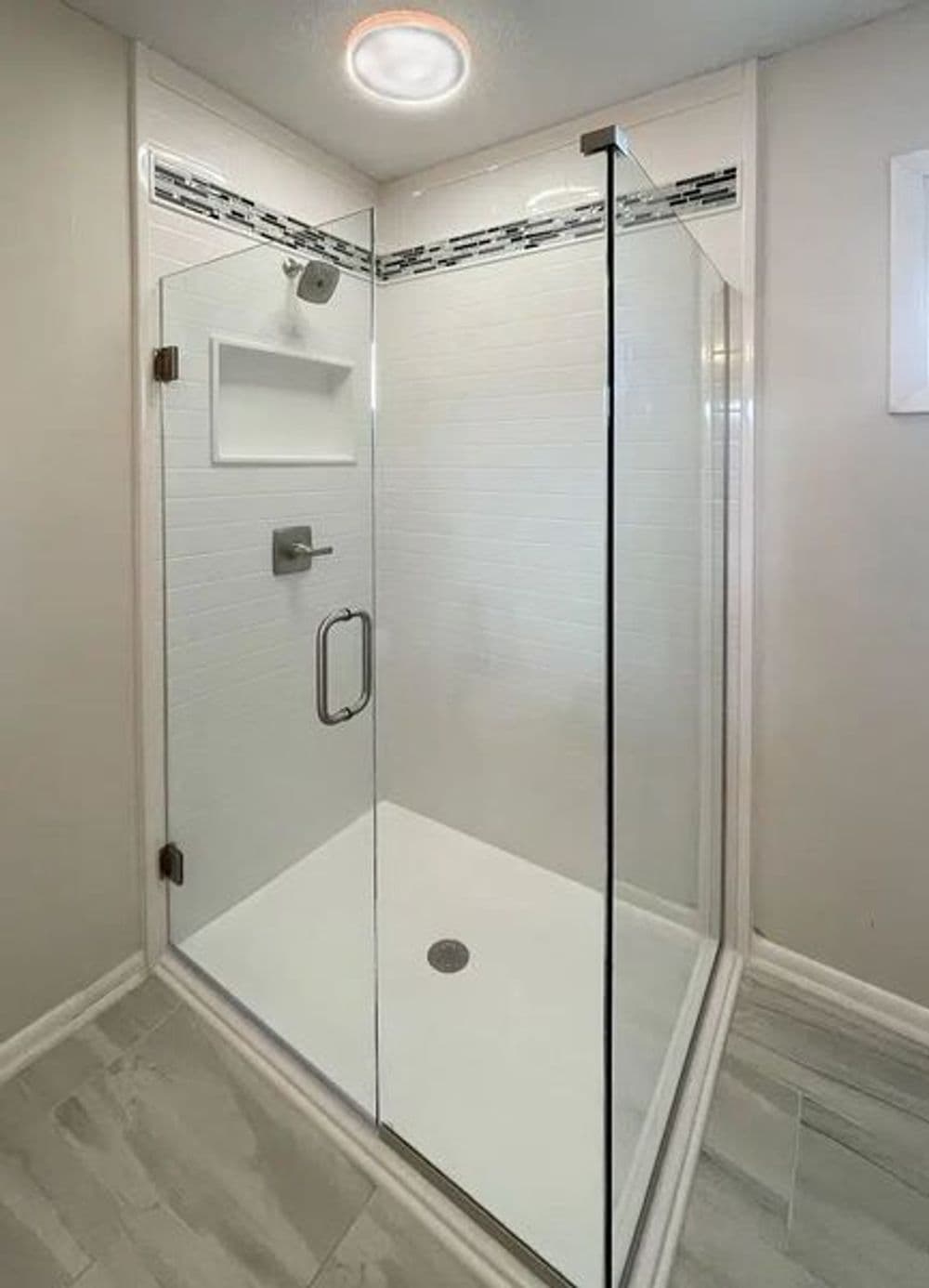 Modern glass shower enclosure with sleek design and minimalist tile decor.